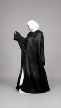 Abaya Farasha Roses noire, satin fluide, coupe papillon – ZYNA